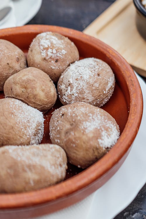Potatoes in a bowl with sugar and salt on a plate
