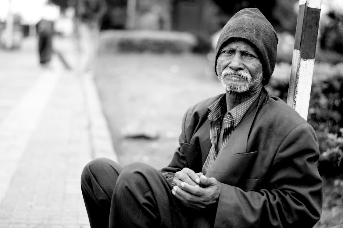 Grayscale Photography of Man Sitting