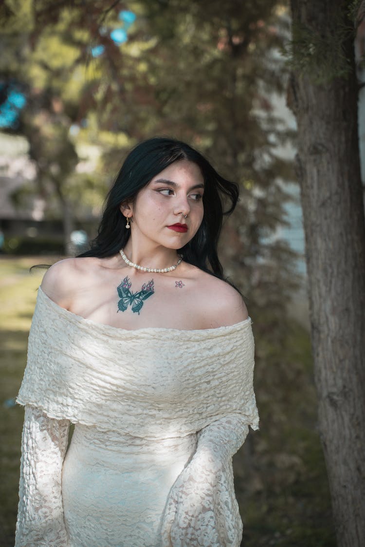 Beautiful Brunette Woman In Dress Posing Next To Tree