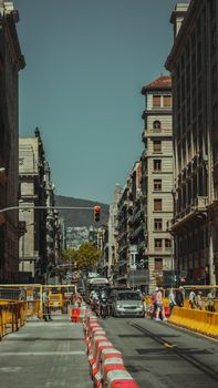 Street view of Barcelona with traffic barriers and architecture on a clear day.