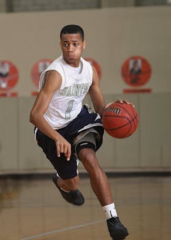 精力充沛的篮球运动员正在室内球场运球