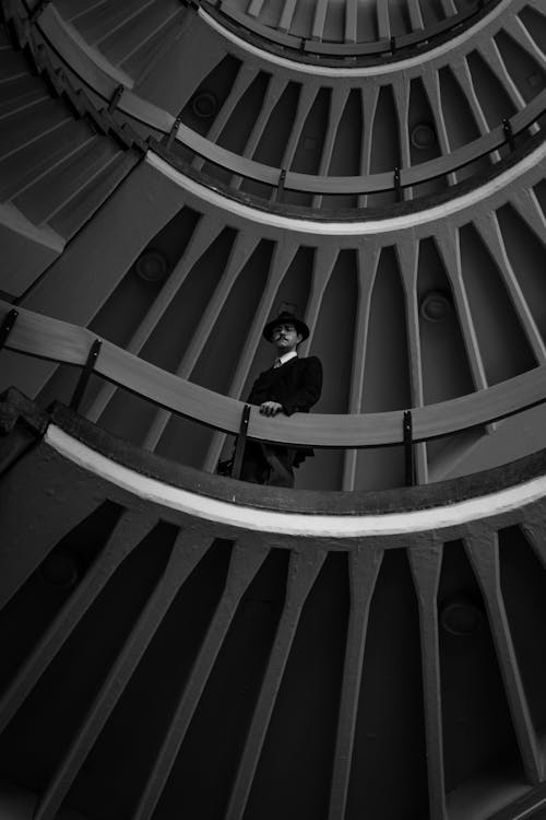 A man is standing in the middle of a spiral staircase
