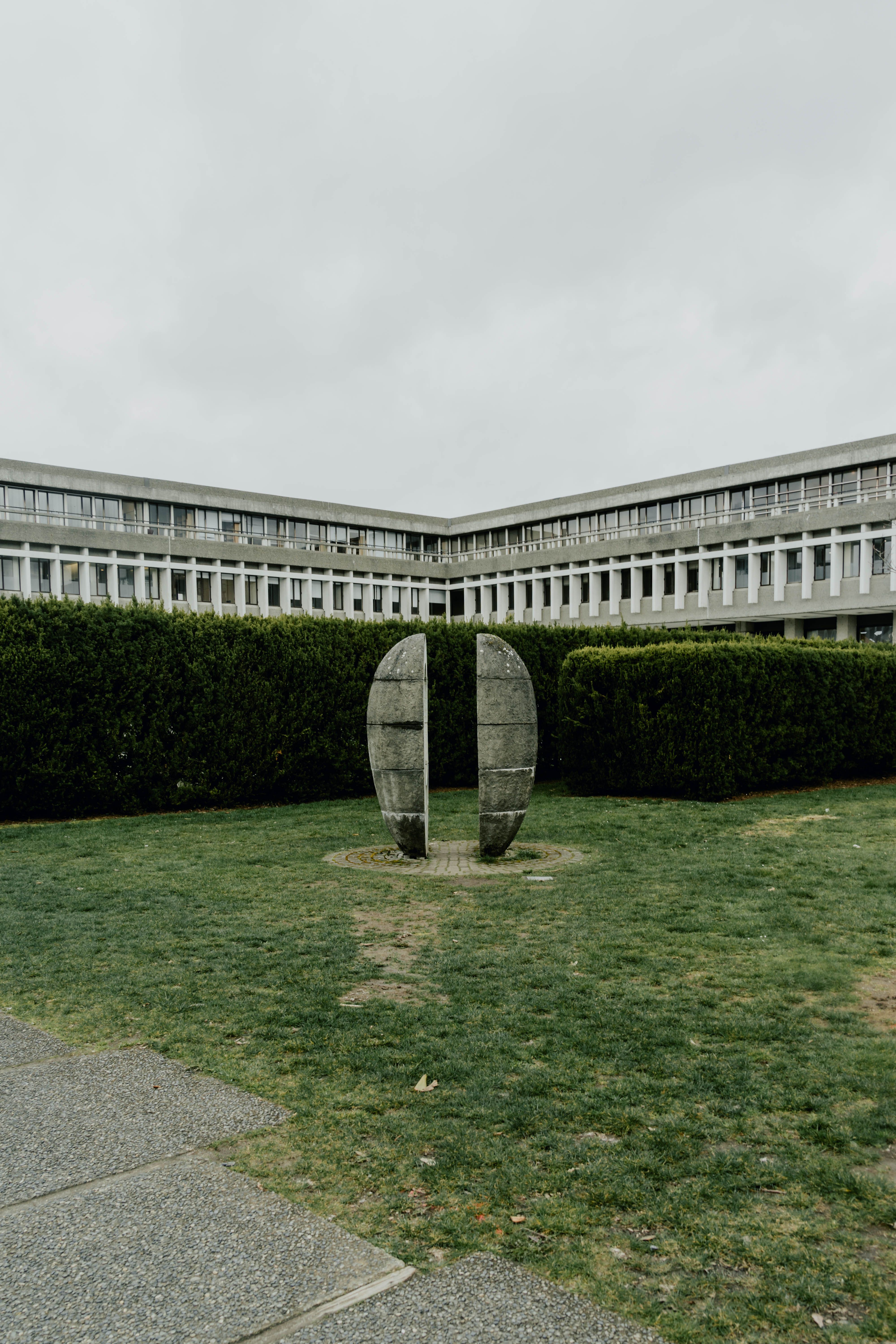 A sculpture in front of a building with grass · Free Stock Photo