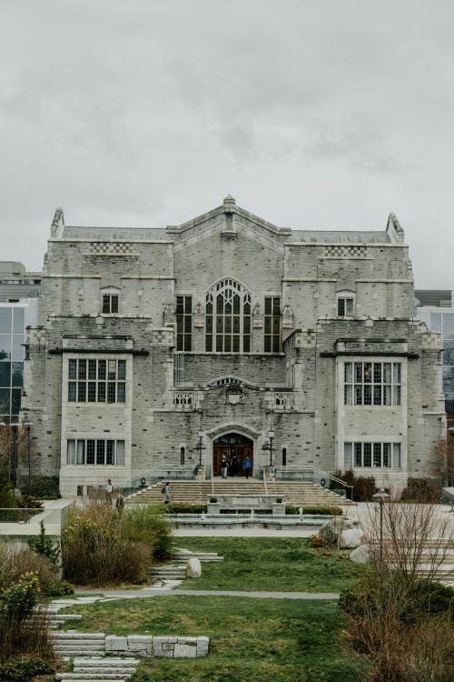 Free A historic stone building with intricate design in Burnaby, surrounded by a landscaped garden. Stock Photo