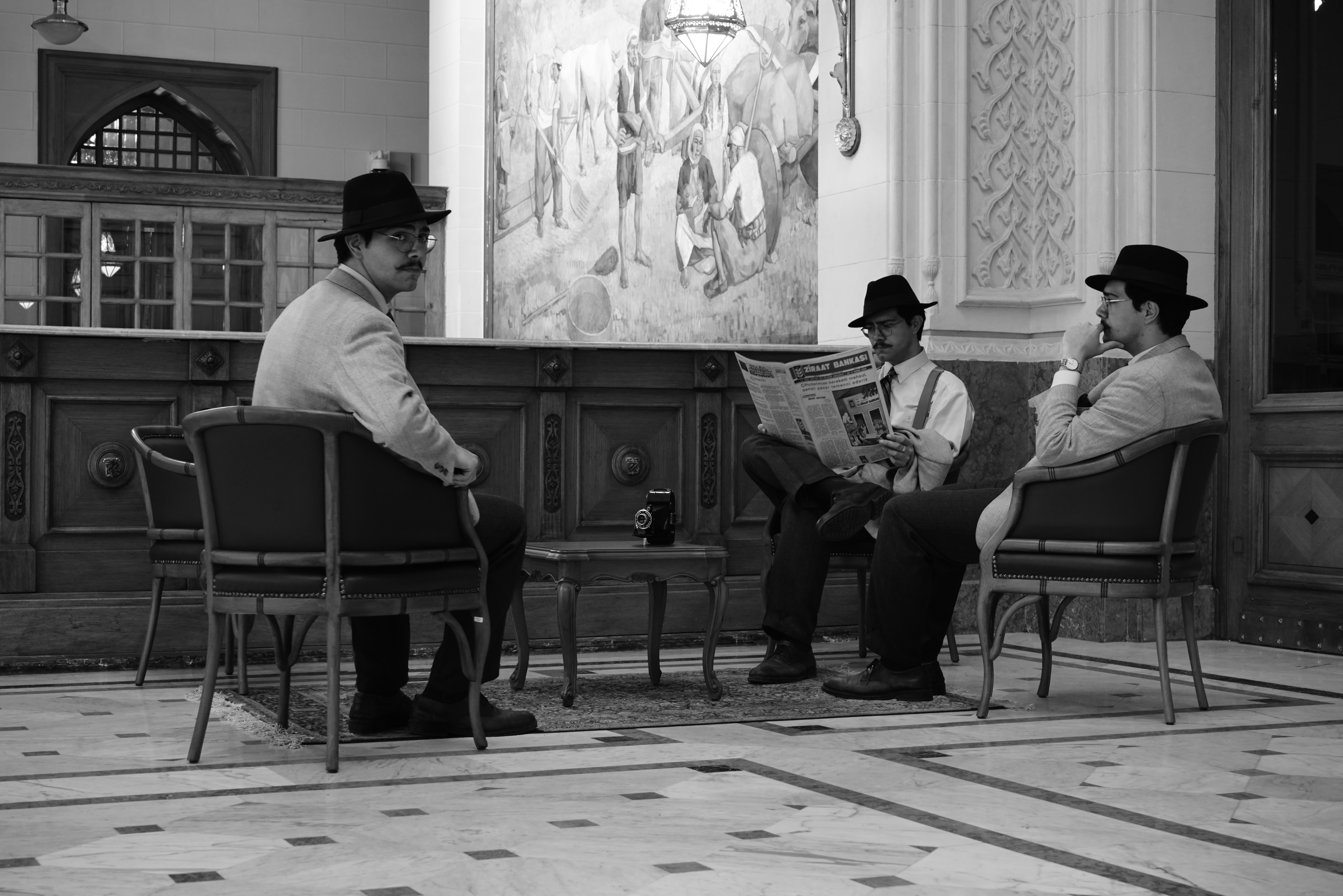 Three men sitting in a room with a table · Free Stock Photo