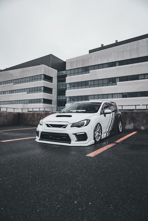 A white subaruna parked in front of a building