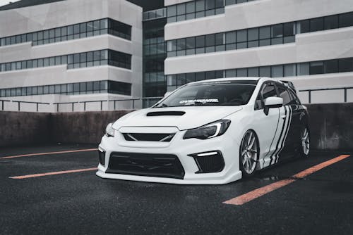 A white subaruna parked in front of a building