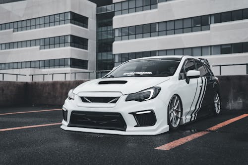 A white subaruna parked in front of a building