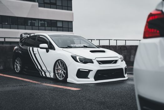 Tuned Subaru WRX with custom livery parked in an urban environment.