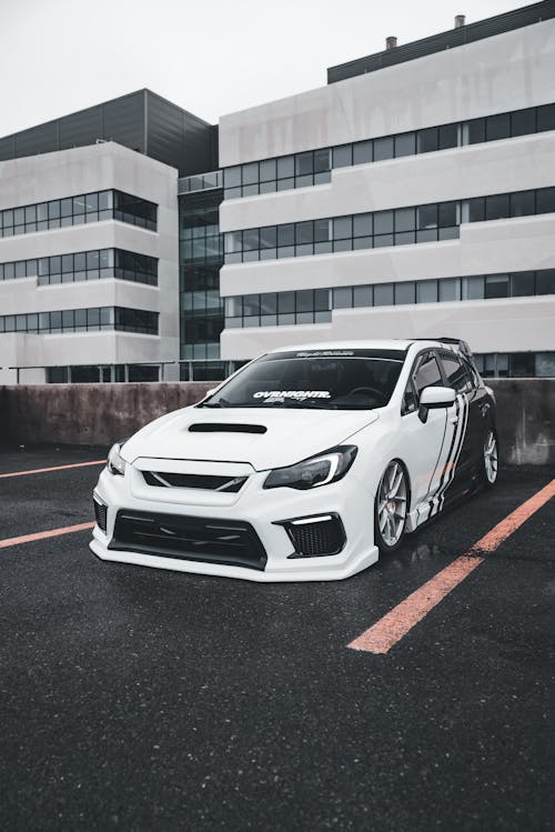 A white subaruna parked in front of a building