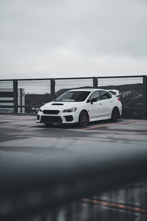 A white subaruna parked on a bridge