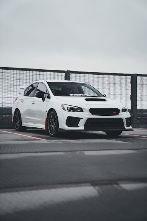 A white subaruna parked on a concrete surface