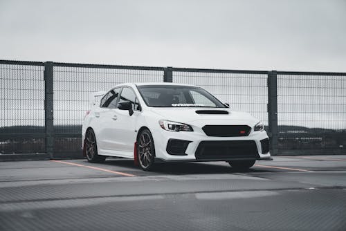 A white subaruna parked on a road