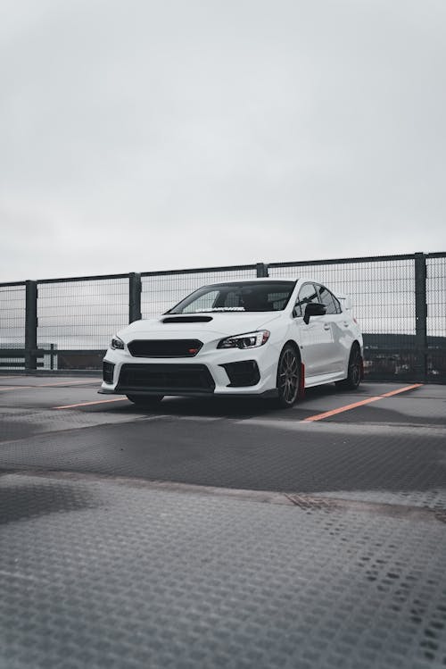 A white subaruna parked on a parking lot