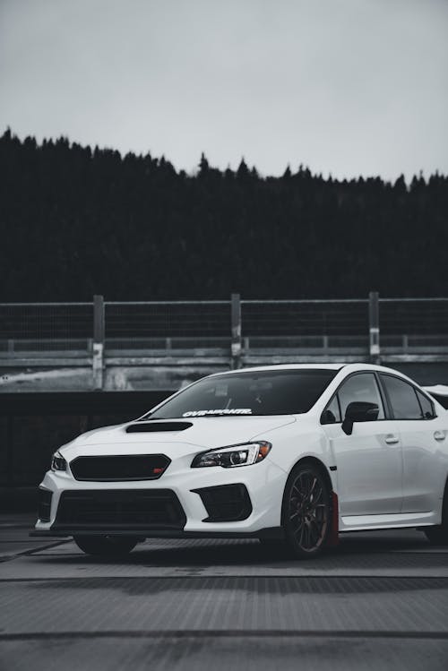 A white subaruna parked on a road