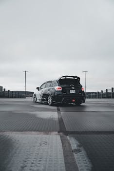 A tuned Subaru WRX sports car captured in a sleek urban environment, showcasing aftermarket livery.