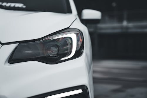 A close up of a white car with headlights