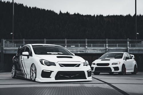 Two subarunas parked in front of a black and white background