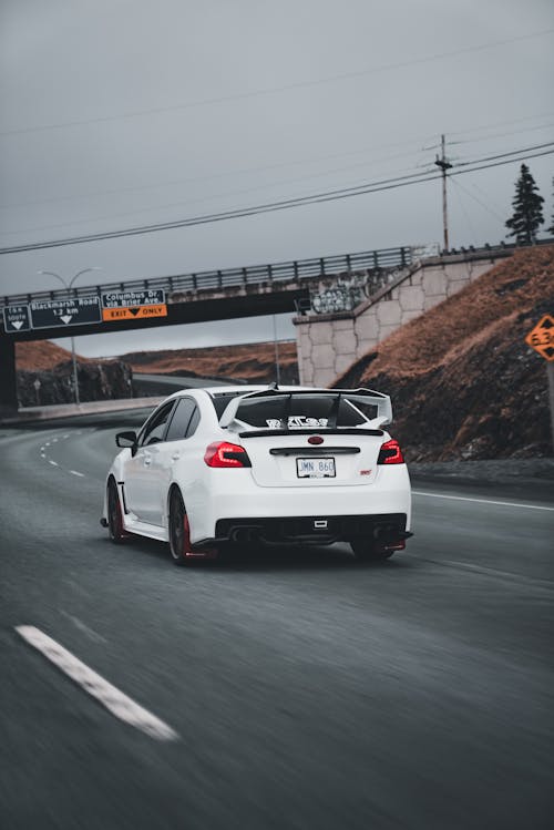 A white car driving down a highway