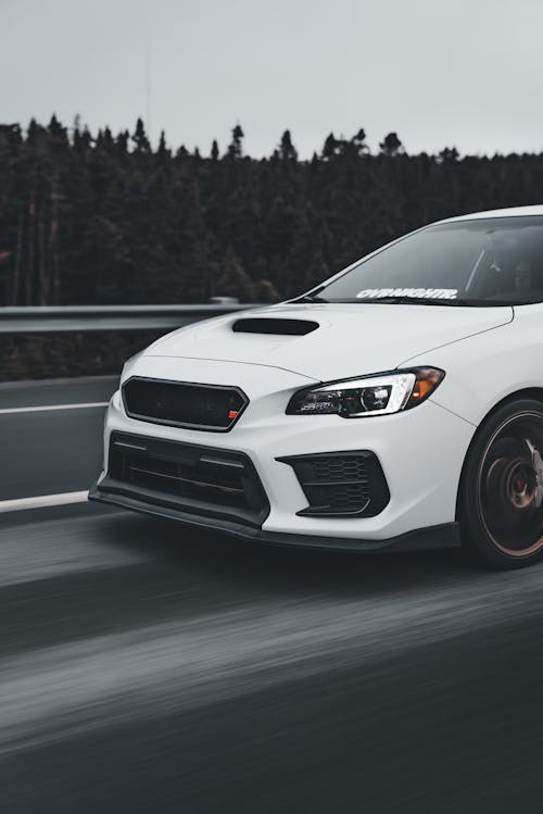 A white subaruna driving on the road