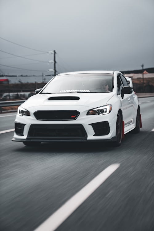 A white subaruna driving down a highway