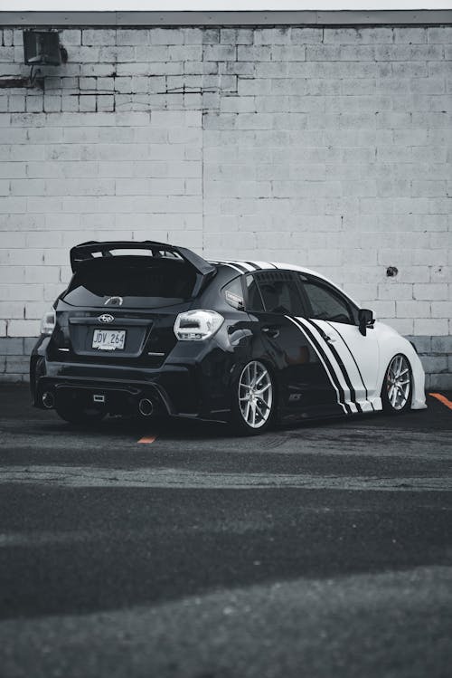 A black and white car parked in front of a building