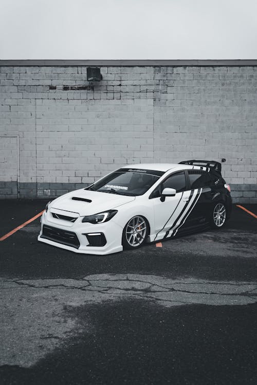 A white subaruna parked in front of a building