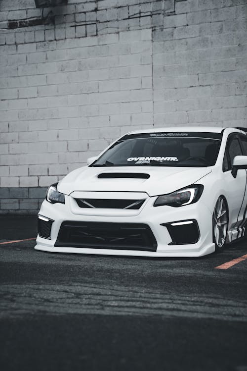 A white subaruna parked in front of a building