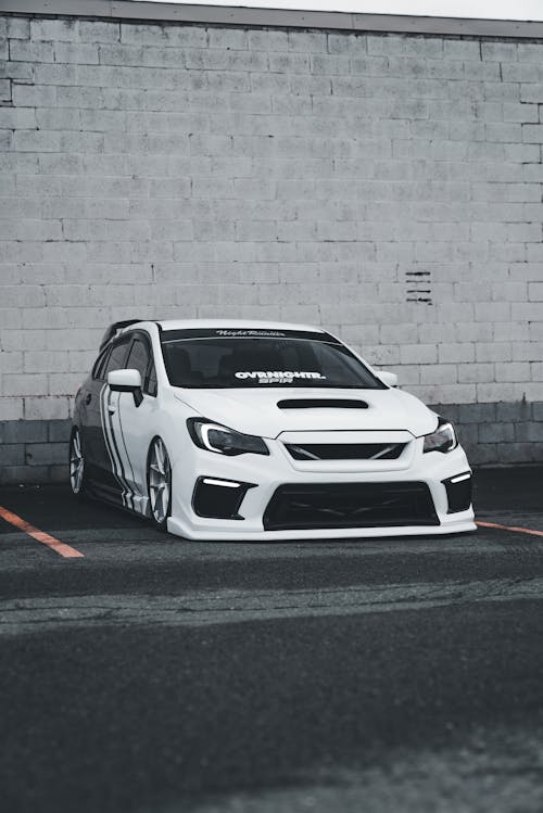 A white subaruna parked in front of a building