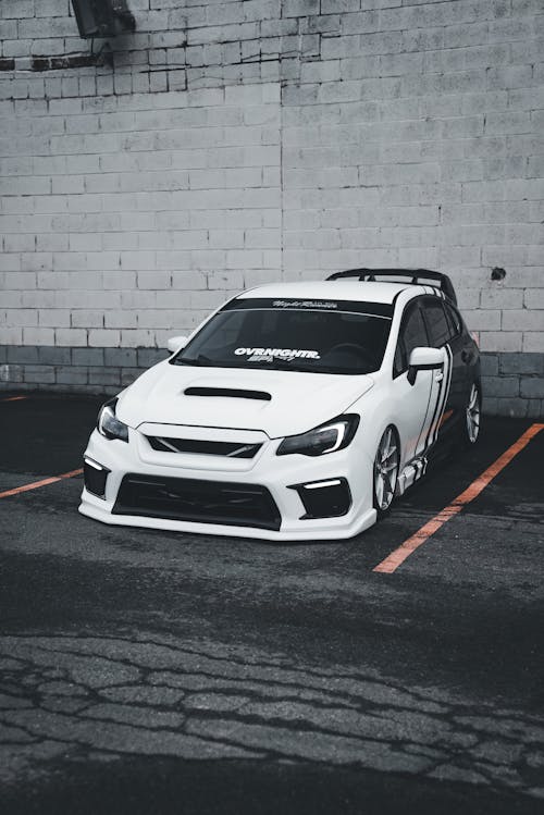 A white subaruna parked in a parking lot