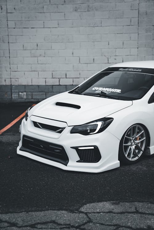A white subaruna with a hood and a spoiler