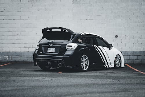 A black and white car parked in front of a building