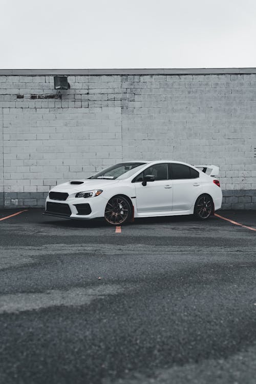 A white subaruna parked in front of a building