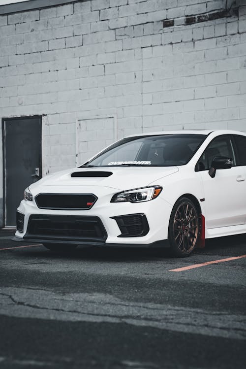 A white subaruna parked in front of a building