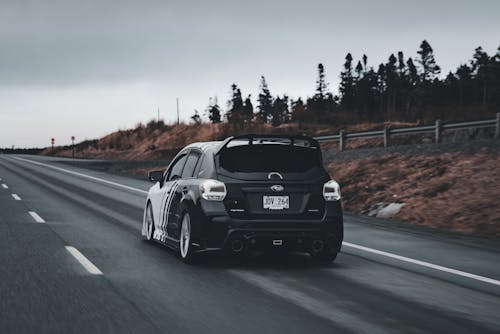 A car driving down the road on a cloudy day