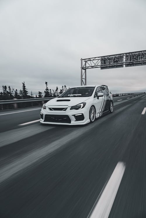 A car driving on a highway with a sign