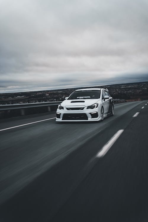 A white car driving on a highway