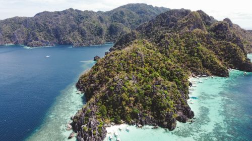 Free Discover the breathtaking aerial view of Coron with lush hills and vibrant blue waters in the Philippines. Stock Photo
