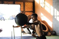 运动员在室内用沙袋练习拳击，展现力量与专注