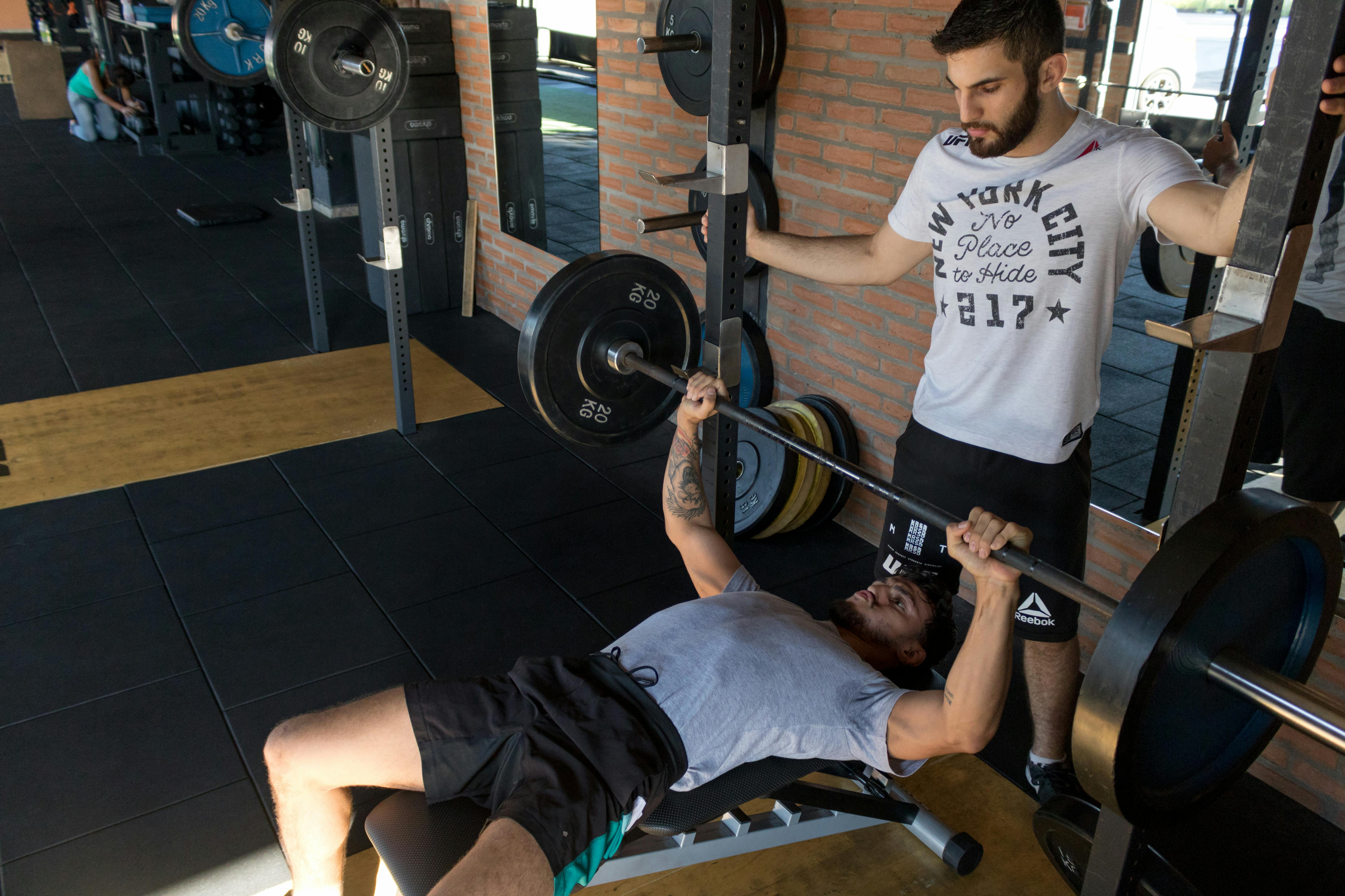 Trainer supervising bench press exercise