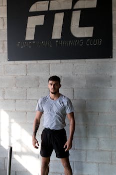 健身房里，一名健美男子表情严肃地站着，彰显出对健身的奉献精神