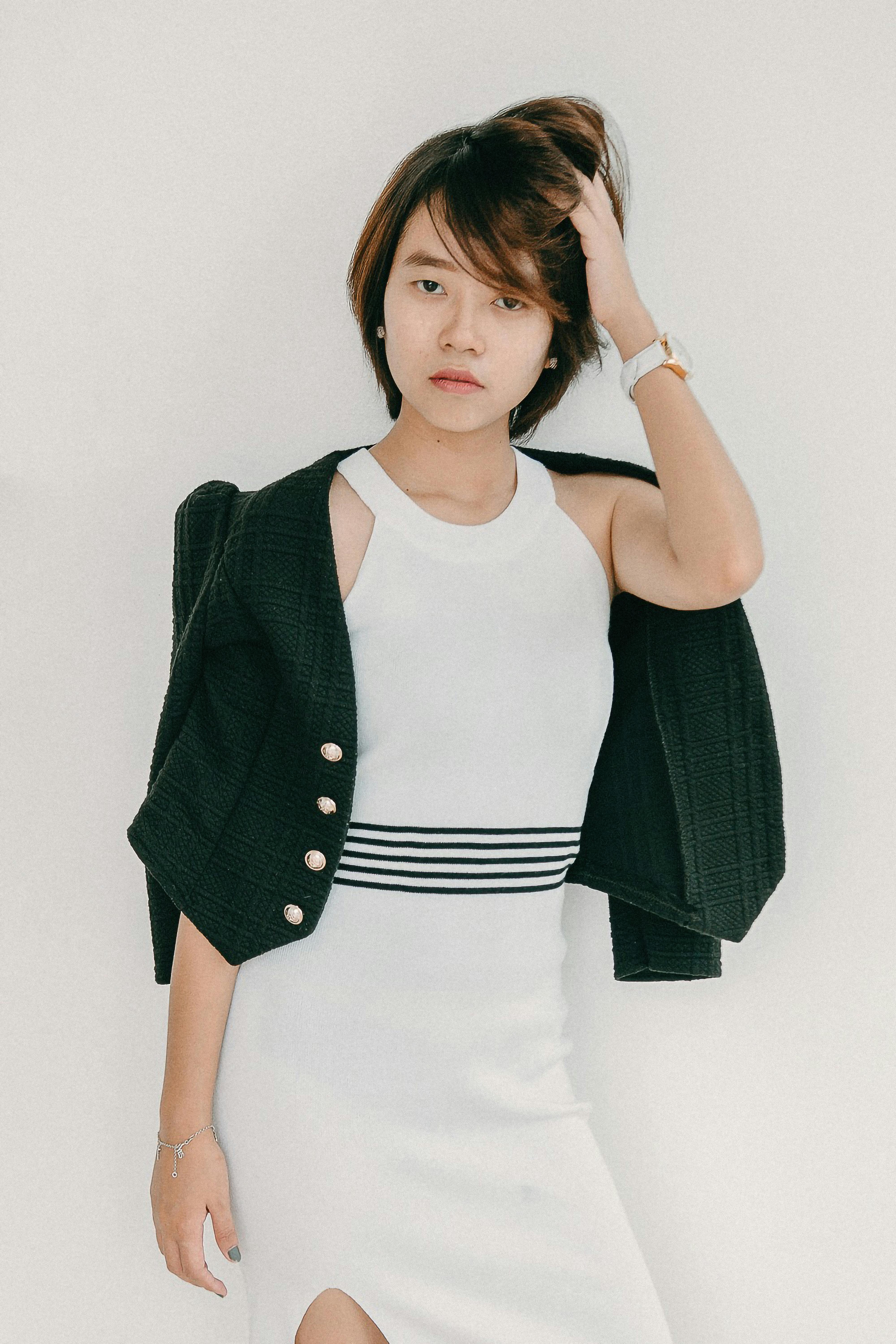 Stylish young woman posing in a modern dress with a confident gaze.