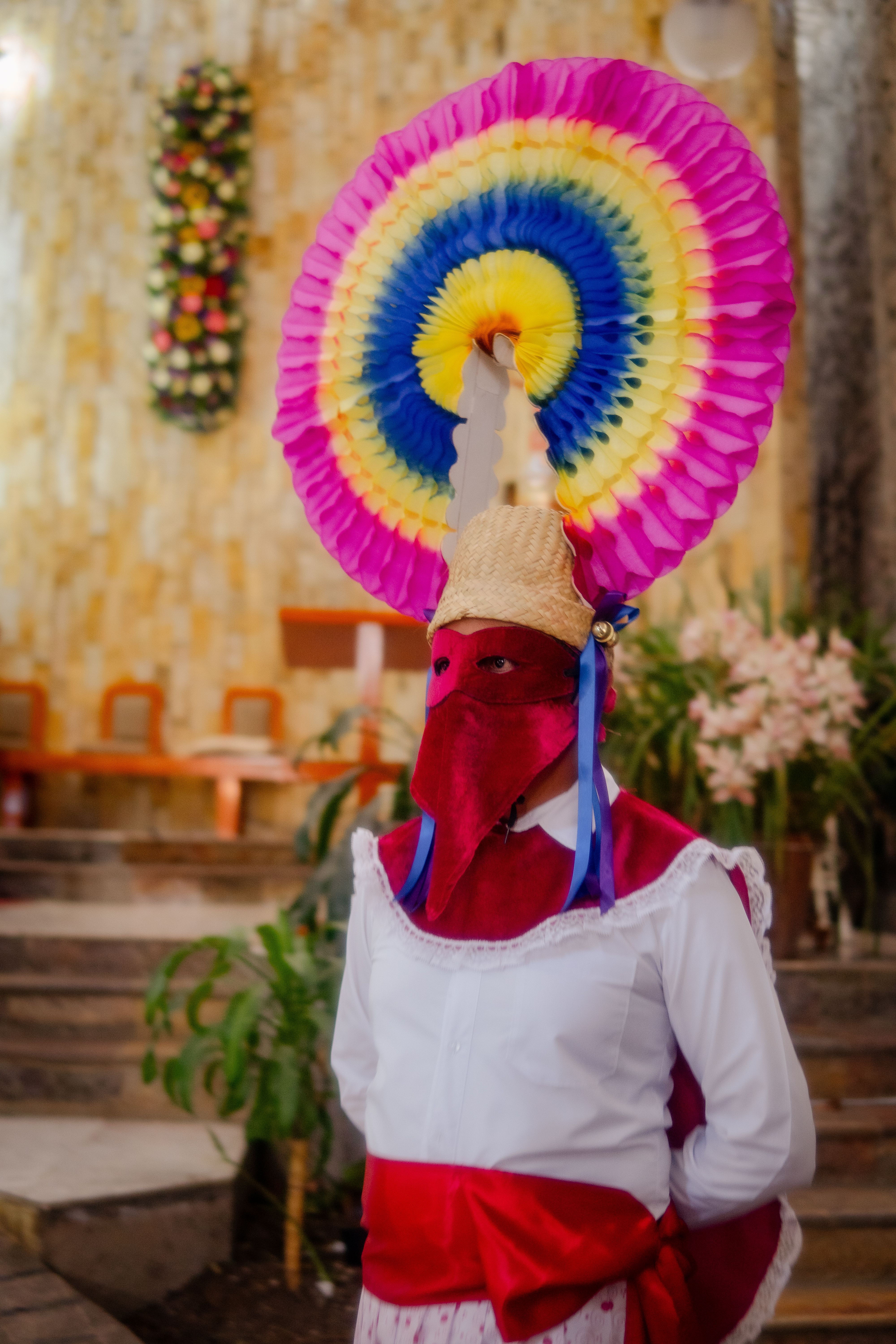 Person in vibrant traditional attire at Mexican cultural event in Huauchinango.