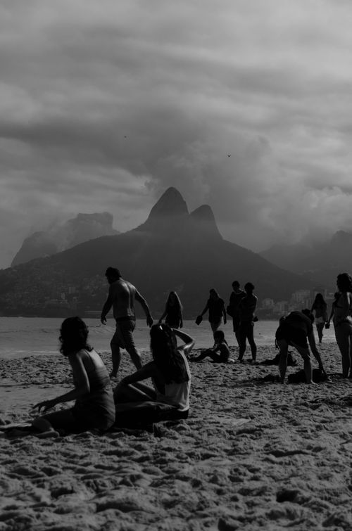Free Silhouetted people on Ipanema Beach with Dois Irmãos mountain in the background, Rio de Janeiro. Stock Photo