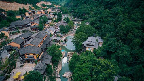 Free Aerial shot of a picturesque village surrounded by lush greenery in Jiangxi, China. Stock Photo