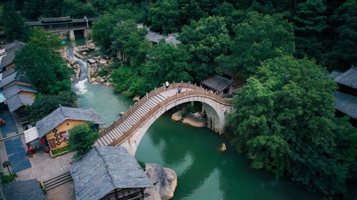 Free Aerial view of a historic stone bridge over a river surrounded by greenery in Jiangxi, China. Stock Photo