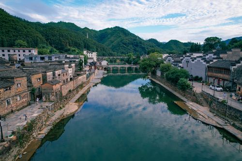 Free Beautiful village in Jiangxi Province, China with river, bridge, and mountains in the background. Stock Photo