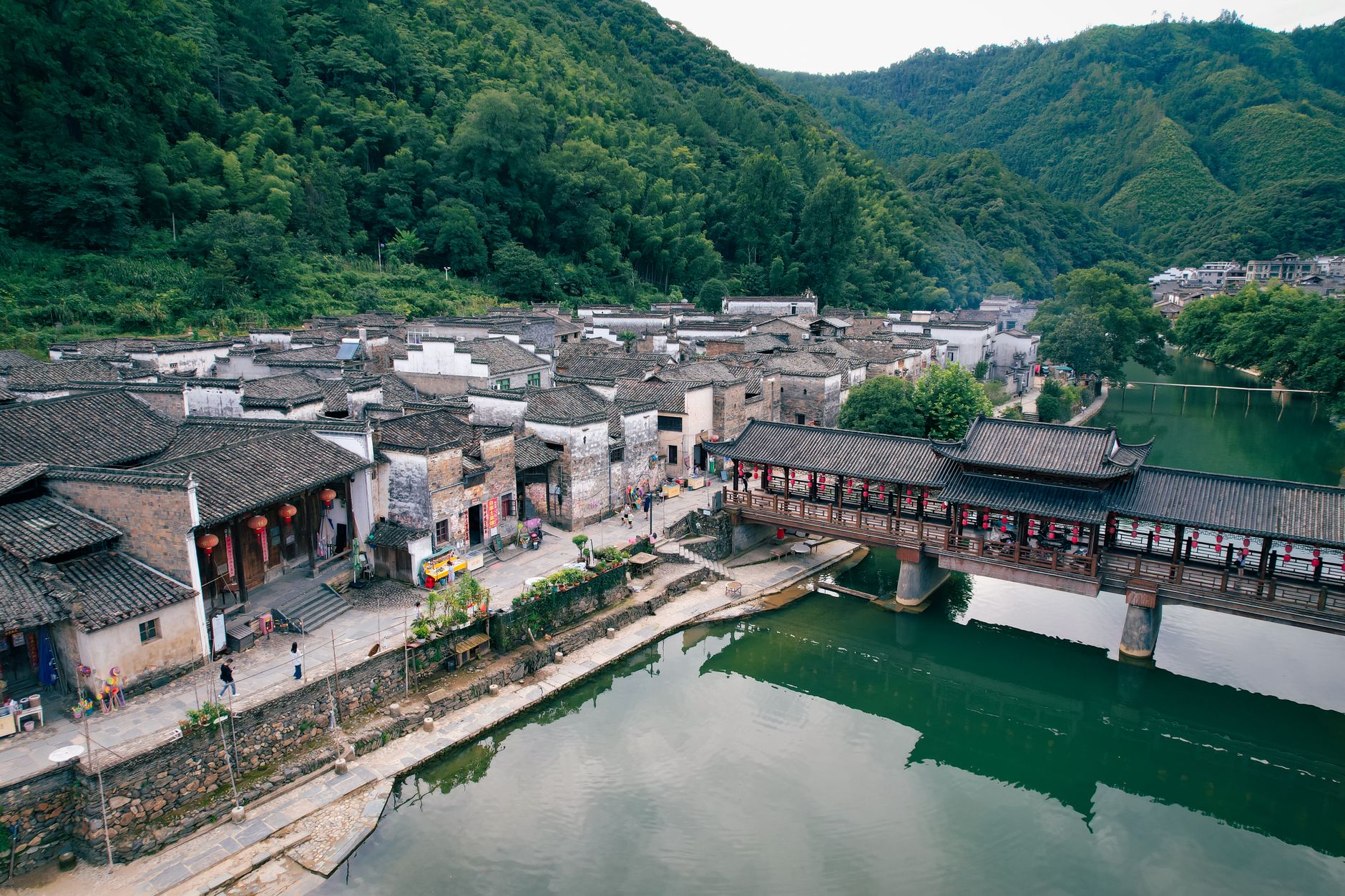 A scenic aerial shot capturing a traditional village and river in Jiangxi, China. Ideal for travel and culture themes.