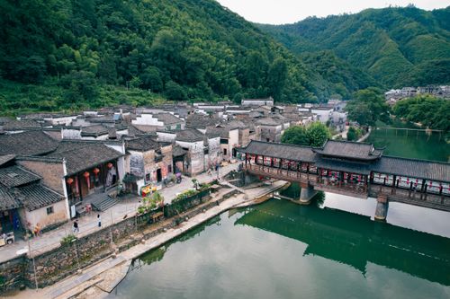 Free A scenic aerial shot capturing a traditional village and river in Jiangxi, China. Ideal for travel and culture themes. Stock Photo
