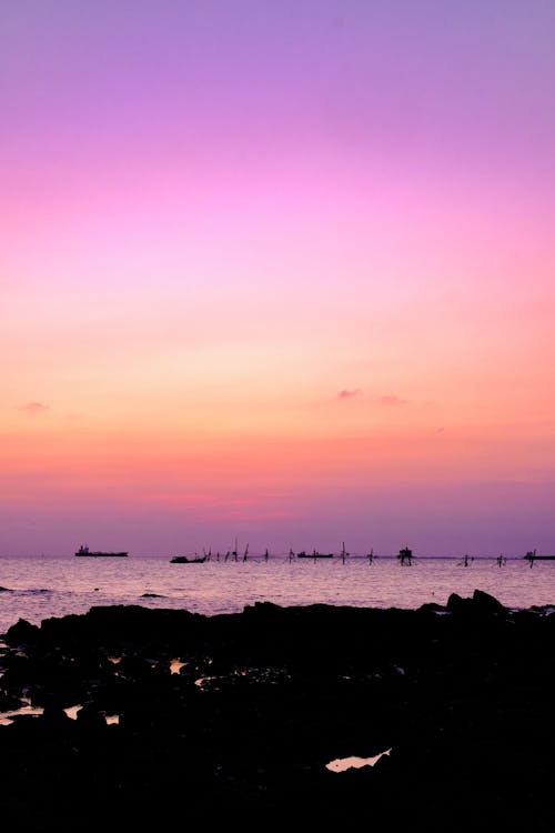 Foto stok gratis latar belakang pantai, laut biru, matahari terbenam di pantai